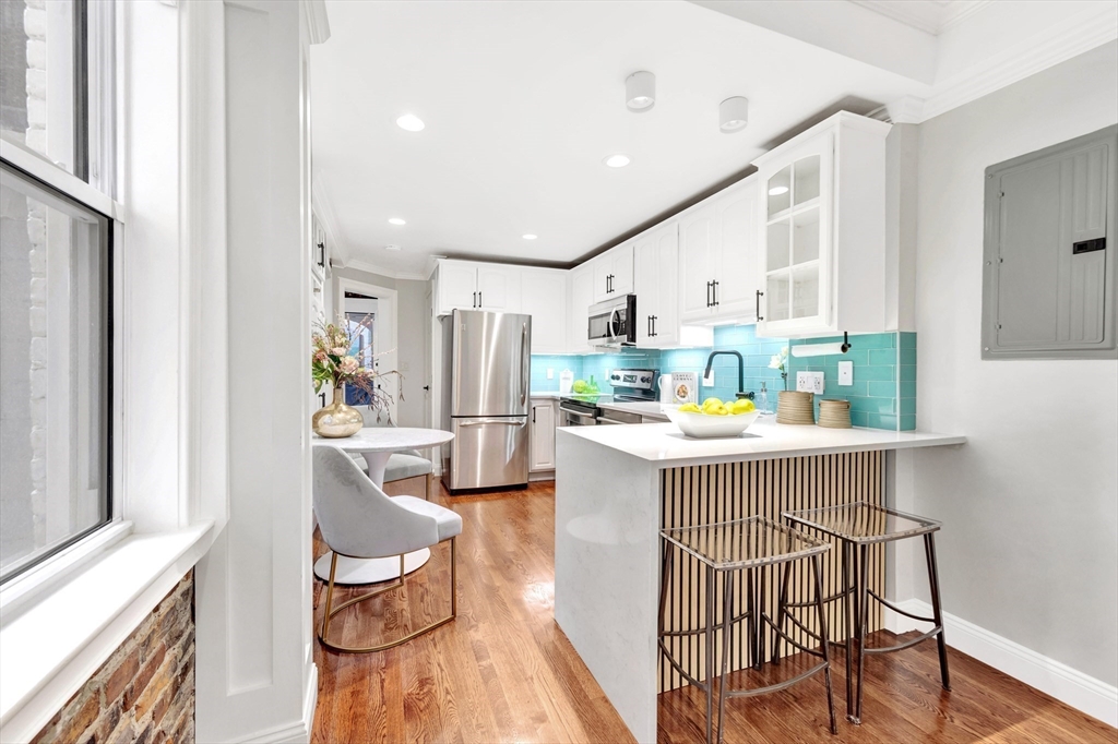 34 Clark Street, Unit 2 Boston, MA 02113 - Photo 7 of 23 a kitchen with stainless steel appliances kitchen island granite countertop furniture and a refrigerator