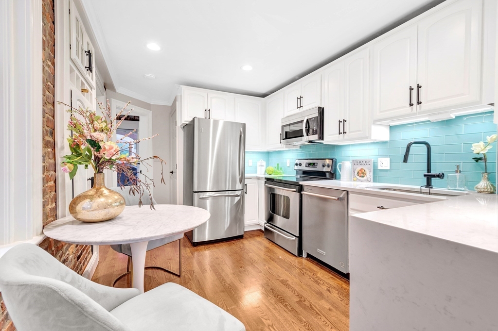 34 Clark Street, Unit 2 Boston, MA 02113 - Photo 10 of 23 a kitchen with stainless steel appliances kitchen island granite countertop a refrigerator a sink a stove and white cabinets with wooden floor