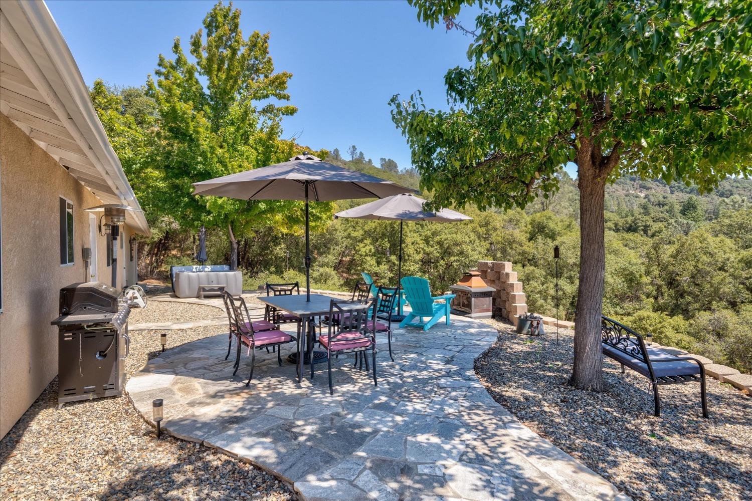 41175 Jean Road West Oakhurst, CA 93644 - Photo 32 of 43 a view of a patio with a table and chairs under an umbrella
