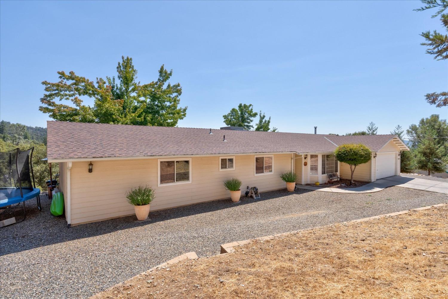 41175 Jean Road West Oakhurst, CA 93644 - Photo 36 of 43 a front view of a house with a yard and a garage