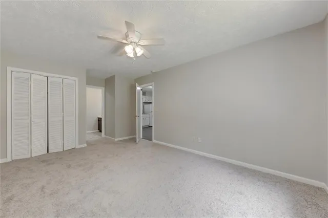 a view of an empty room and chandelier fan