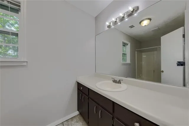 a bathroom with a sink vanity and a mirror