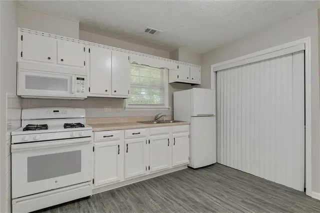 a kitchen with white cabinets and white appliances
