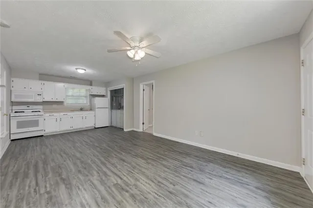 a view of a kitchen with wooden floor and windows