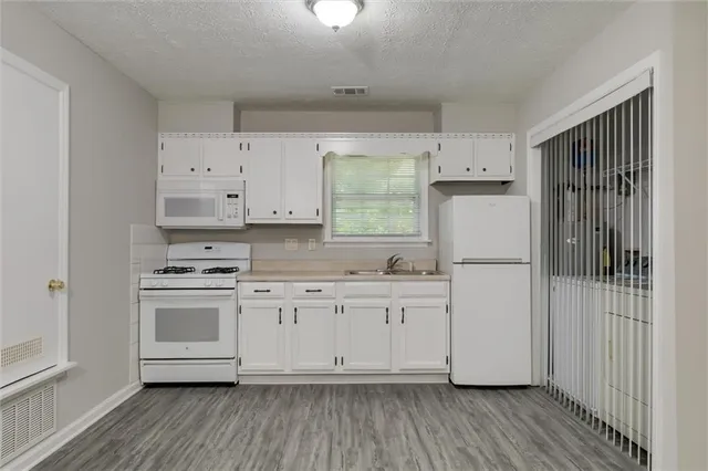 a kitchen with white cabinets and white appliances
