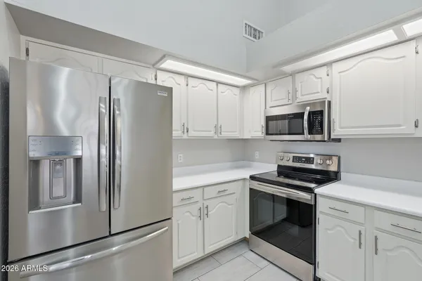 a kitchen with white cabinets and stainless steel appliances