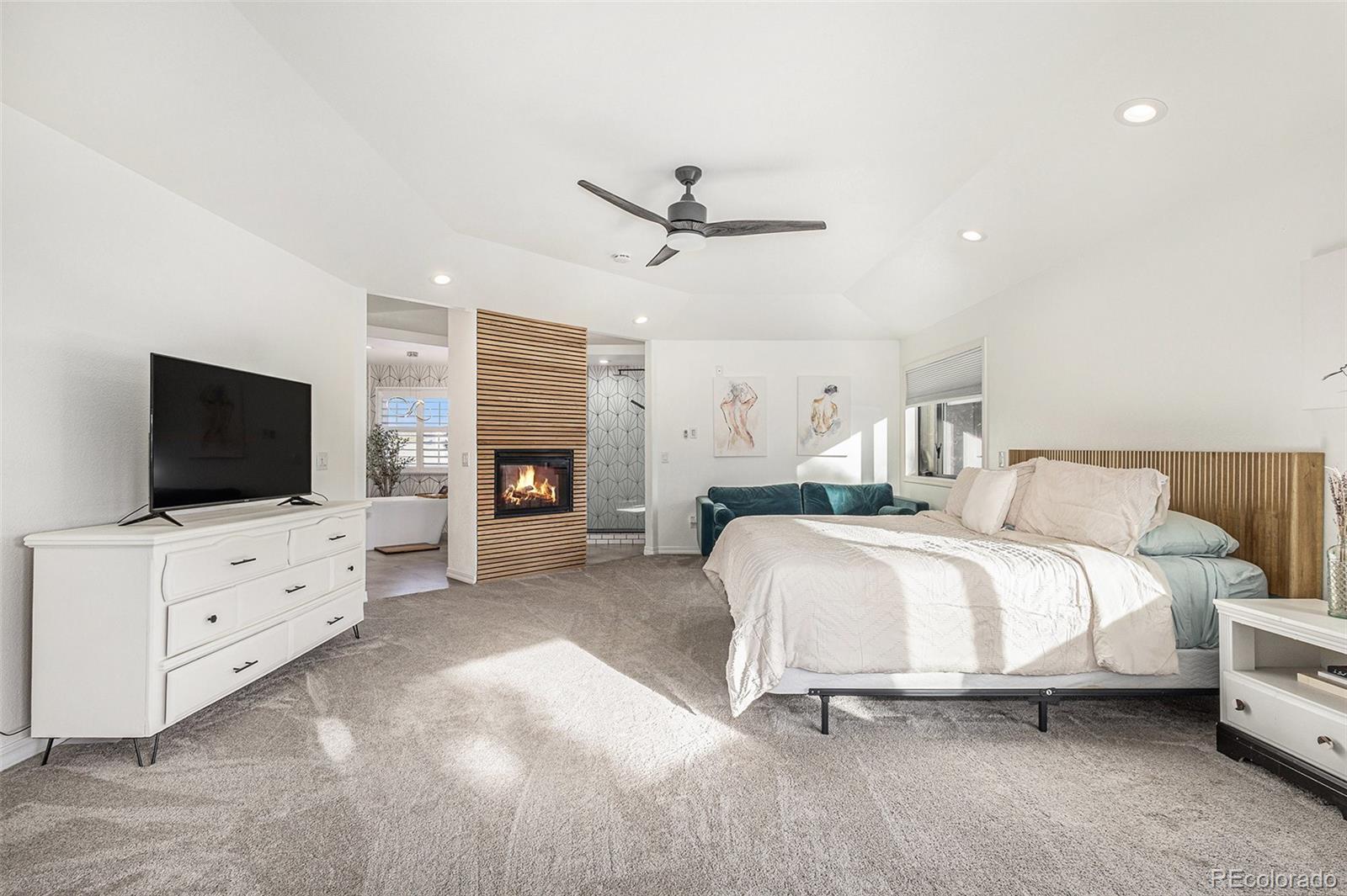 17870 New London Road Monument, CO 80132 - Photo 12 of 44 a spacious bedroom with a bed and a flat screen tv
