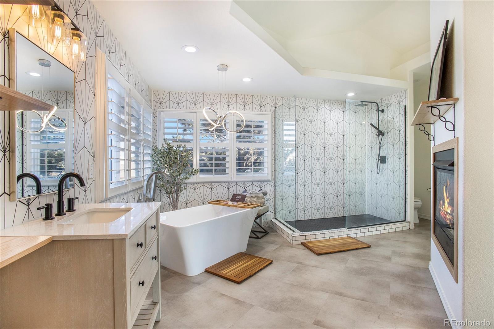 17870 New London Road Monument, CO 80132 - Photo 14 of 44 a bathroom with a tub sink a mirror and a shower