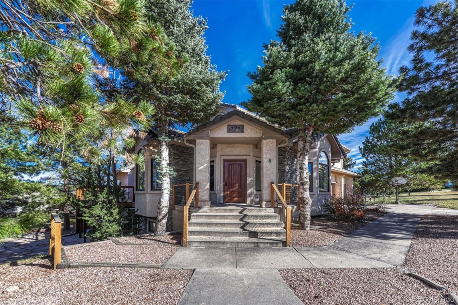 17870 New London Road Monument, CO 80132 - Photo 2 of 44 a view of a house with large trees and plants