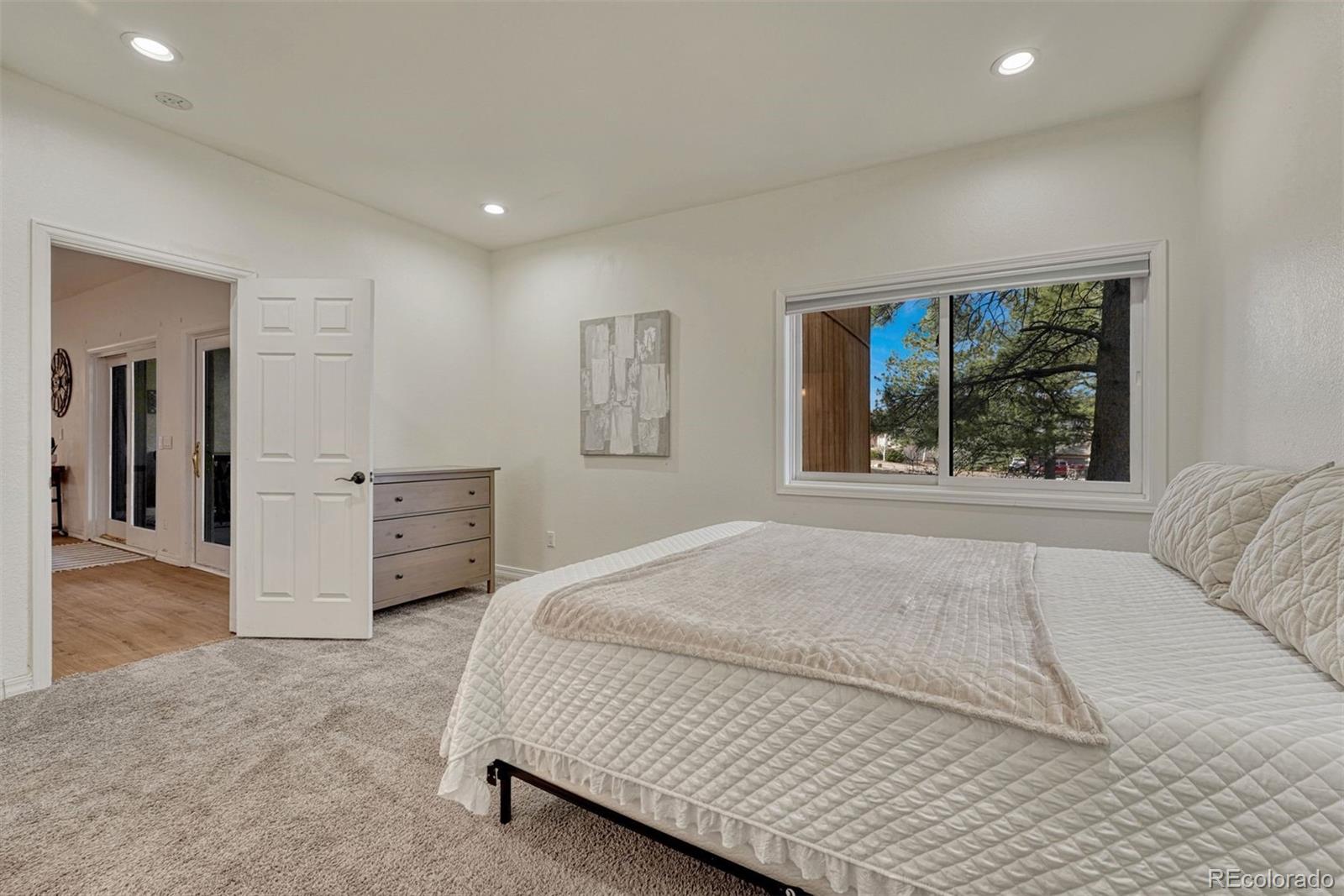 17870 New London Road Monument, CO 80132 - Photo 28 of 44 a spacious bedroom with a large bed and a window