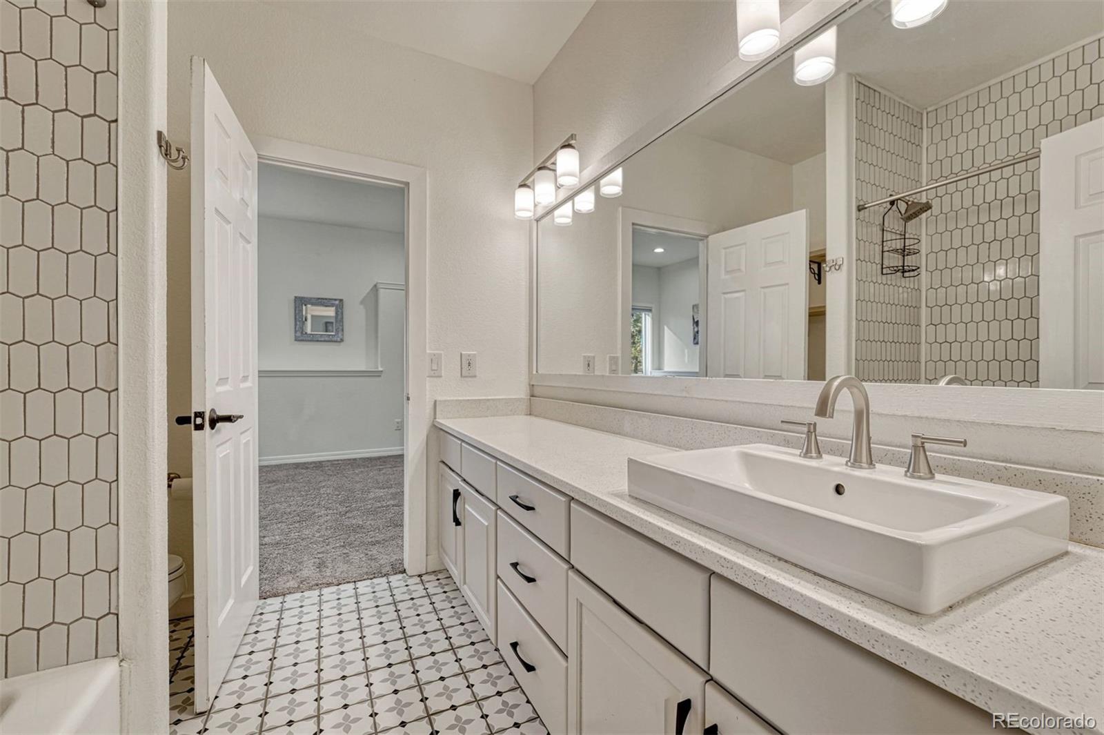 17870 New London Road Monument, CO 80132 - Photo 30 of 44 a spacious bathroom with a sink a mirror and a shower