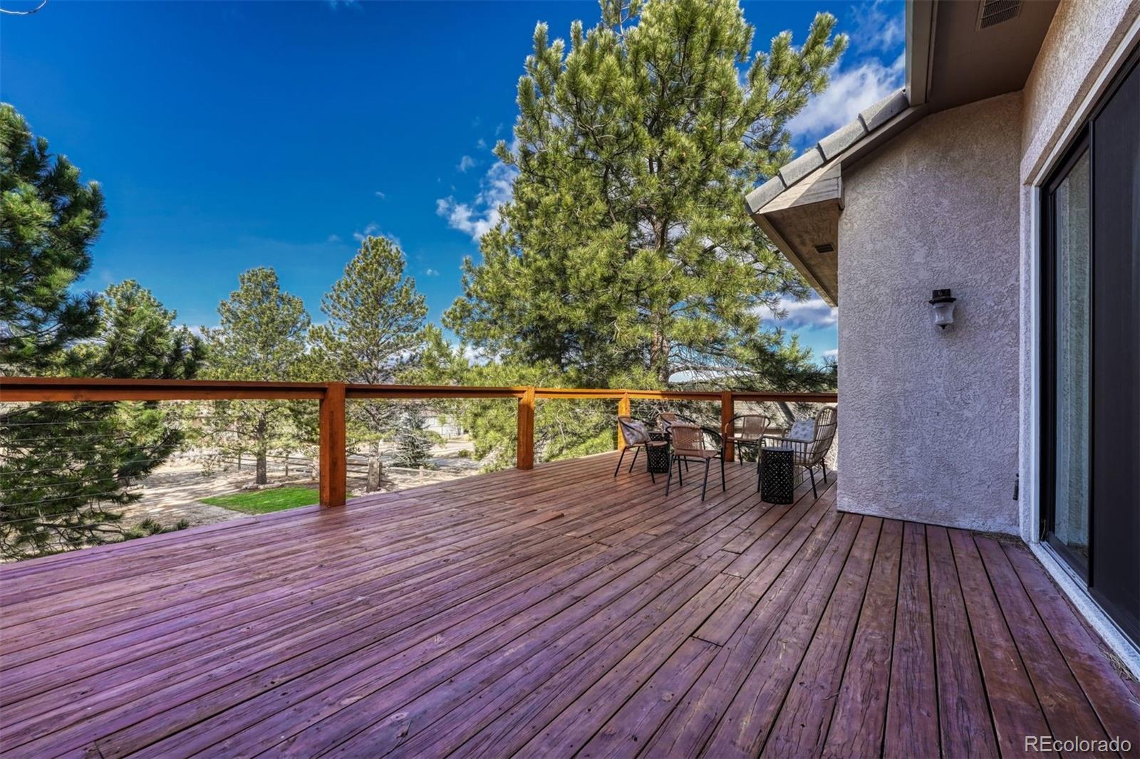 17870 New London Road Monument, CO 80132 - Photo 36 of 44 a balcony with wooden floor table and chairs