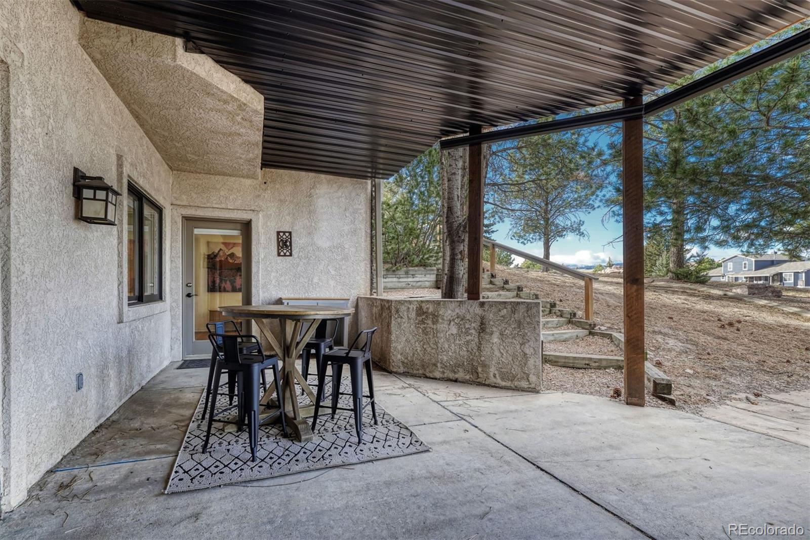 17870 New London Road Monument, CO 80132 - Photo 39 of 44 a view of a patio with table and chairs and wooden floor