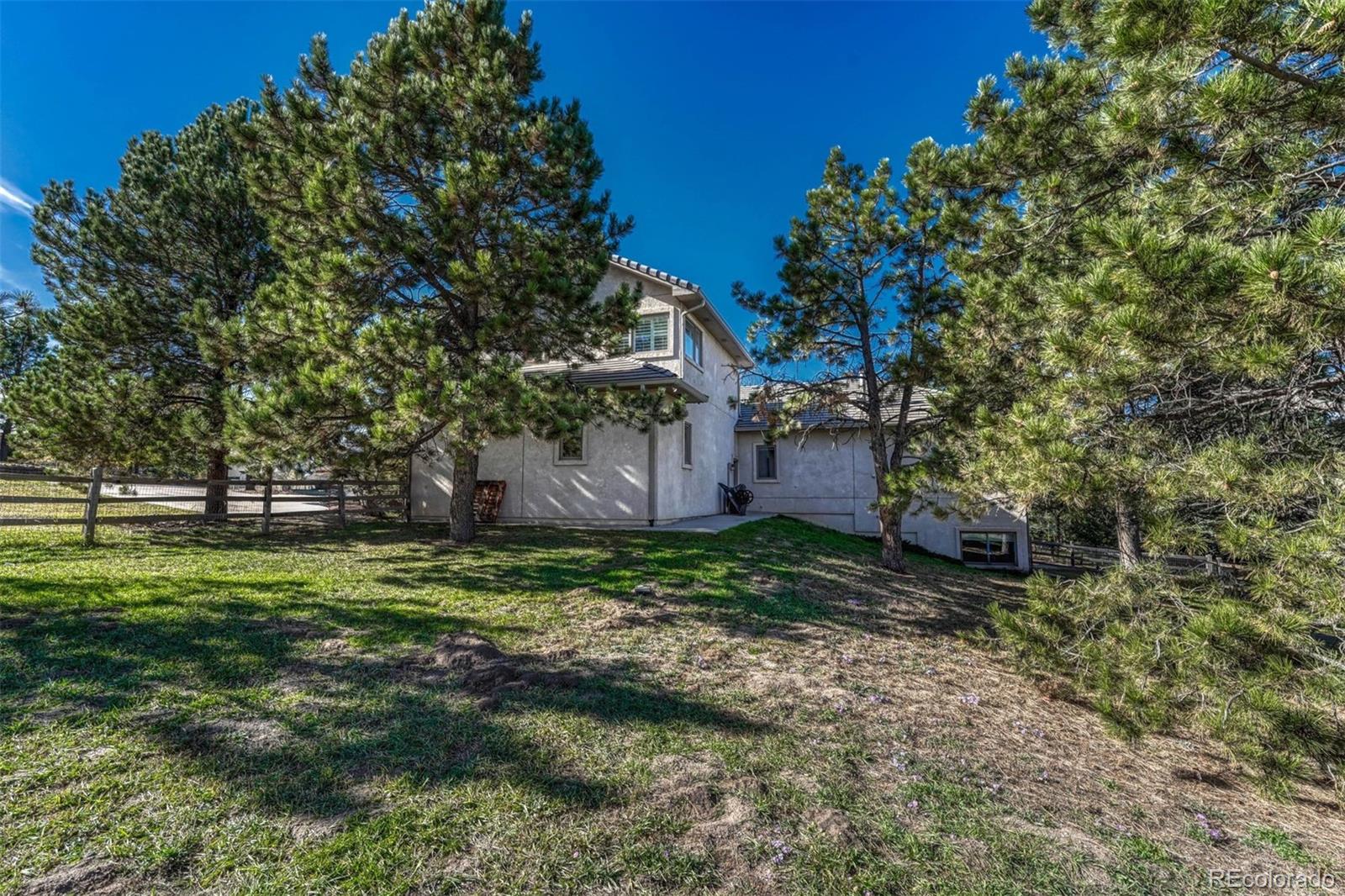 17870 New London Road Monument, CO 80132 - Photo 43 of 44 a backyard of a house with plants and large trees