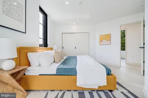 a bedroom with a bed and painting on the wall