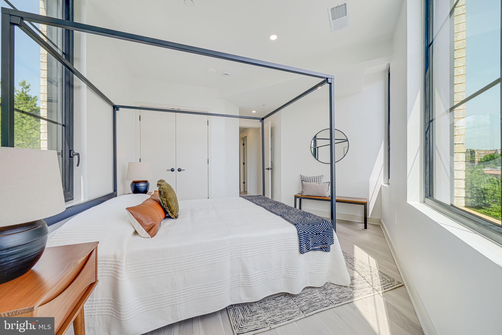 2901 Newark Street Northwest Washington, DC 20008 - Photo 16 of 52 a bedroom with a bed a chandelier and a dresser next to a window