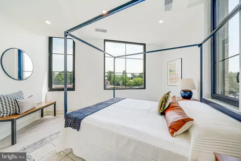 a bedroom with a bed and a large window