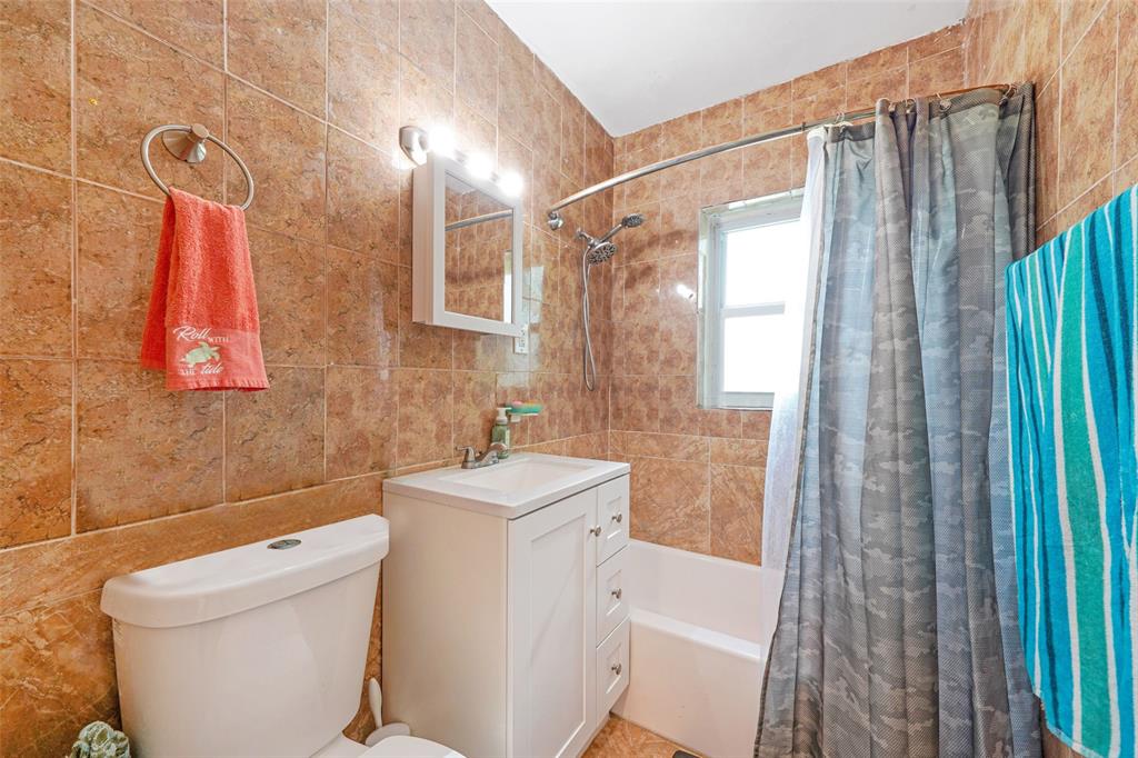 413 Northwest 100th Terrace Miami, FL 33150 - Photo 11 of 29 a bathroom with a sink a toilet and shower curtain