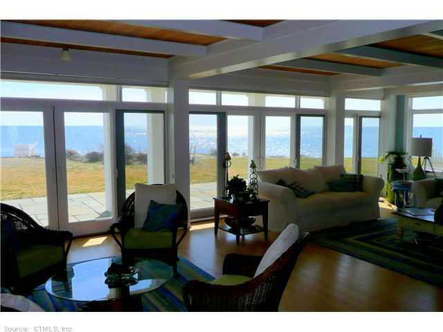 a living room with furniture and floor to ceiling windows