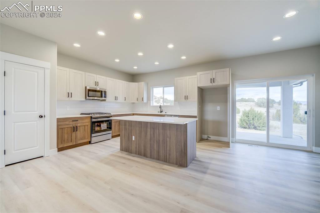 205 High Meadows Drive Florence, CO 81226 - Photo 14 of 49 a large kitchen with a large counter top a sink stainless steel appliances and cabinets