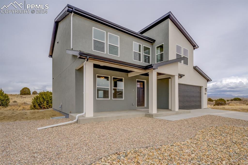 205 High Meadows Drive Florence, CO 81226 - Photo 43 of 49 a front view of a house with a yard and garage
