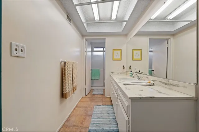 a en suite bathroom with a double vanity sink and a mirror