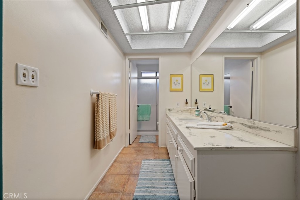 15410 Runnymede Street Van Nuys, CA 91406 - Photo 15 of 22 a en suite bathroom with a double vanity sink and a mirror