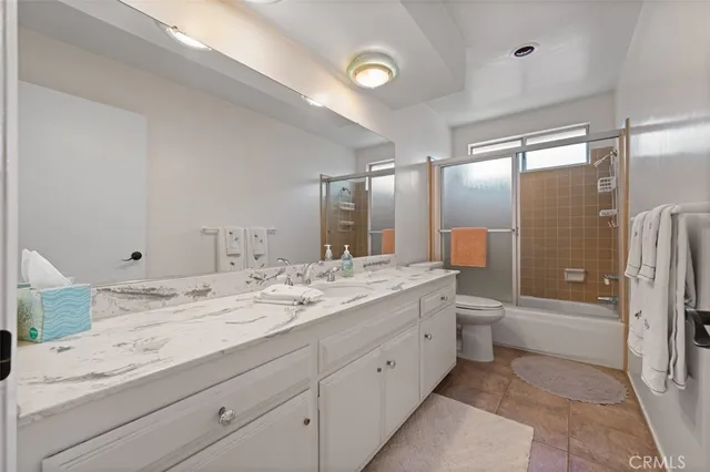 a bathroom with a granite countertop sink mirror and toilet