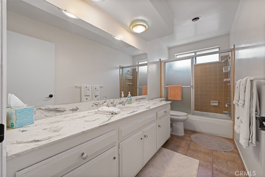 15410 Runnymede Street Van Nuys, CA 91406 - Photo 19 of 22 a bathroom with a granite countertop sink mirror and toilet
