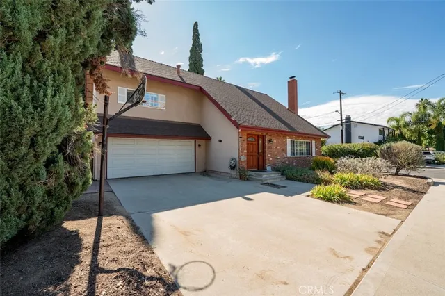 a front view of a house with a yard and potted plants
