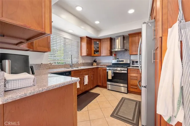 a kitchen with stainless steel appliances granite countertop a stove a sink and a refrigerator