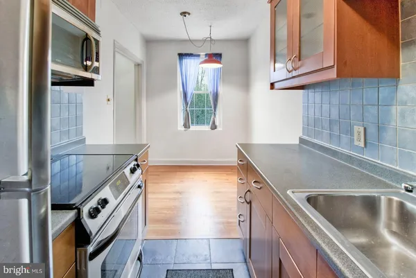 a kitchen with granite countertop a sink and a stove top oven