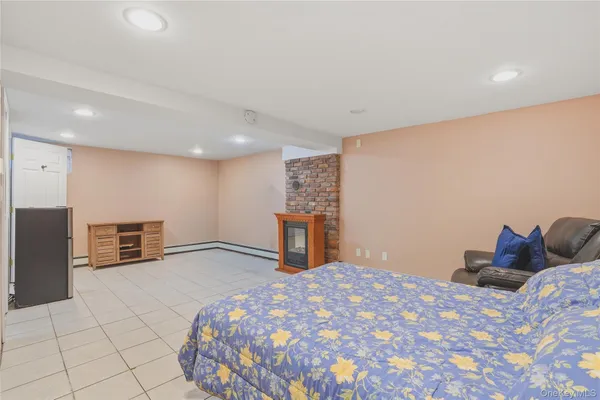 a bedroom with a bed and dresser with mirror