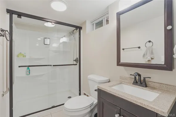 a bathroom with a sink vanity mirror and toilet