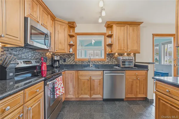 a kitchen with stainless steel appliances granite countertop a sink stove and cabinets