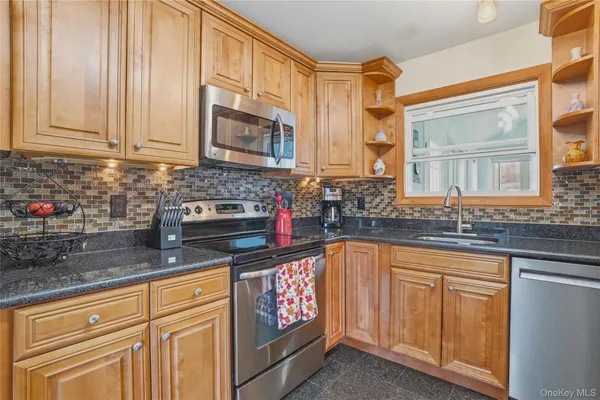 a kitchen with granite countertop a sink stove and cabinets