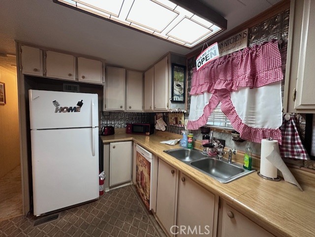 701 Montara Road, Unit 53 Barstow, CA 92311 - Photo 10 of 21 a kitchen with a sink a refrigerator and cabinets
