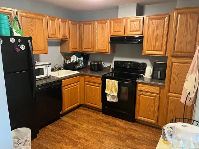 a kitchen with stainless steel appliances granite countertop a refrigerator sink and stove