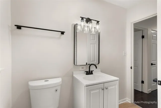 a bathroom with a sink and mirror with toilet