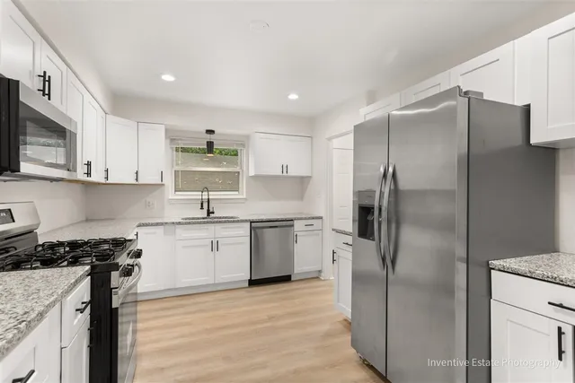a kitchen with a refrigerator sink and cabinets