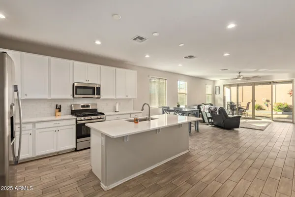 a large kitchen with stainless steel appliances lots of counter space and wooden floor