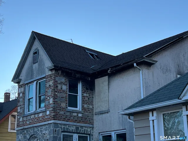 a brick house with large windows and a yard