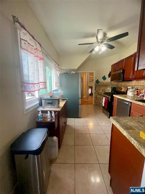 315 Coit Street Irvington, NJ 07111 - Photo 6 of 12 a kitchen with stainless steel appliances granite countertop a sink dishwasher a stove a refrigerator with a dining table and chairs with wooden floor