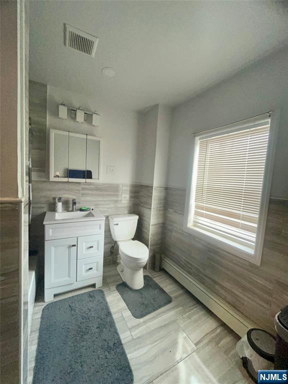 315 Coit Street Irvington, NJ 07111 - Photo 8 of 12 a spacious bathroom with a granite countertop toilet sink and mirror