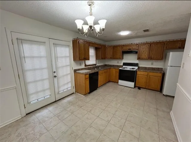 a kitchen with stainless steel appliances a stove a microwave and white cabinets
