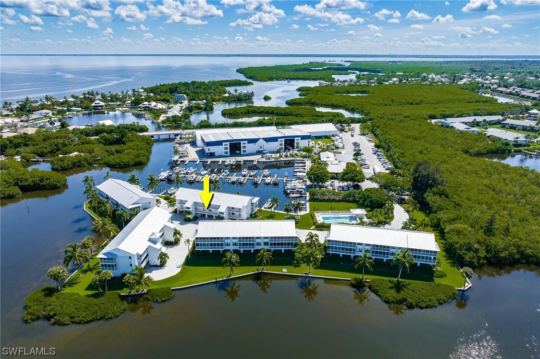 16641 Stringfellow Road, Unit 502 Bokeelia, FL 33922 - Photo 1 of 40 an aerial view of a house with a garden potted plants and large trees
