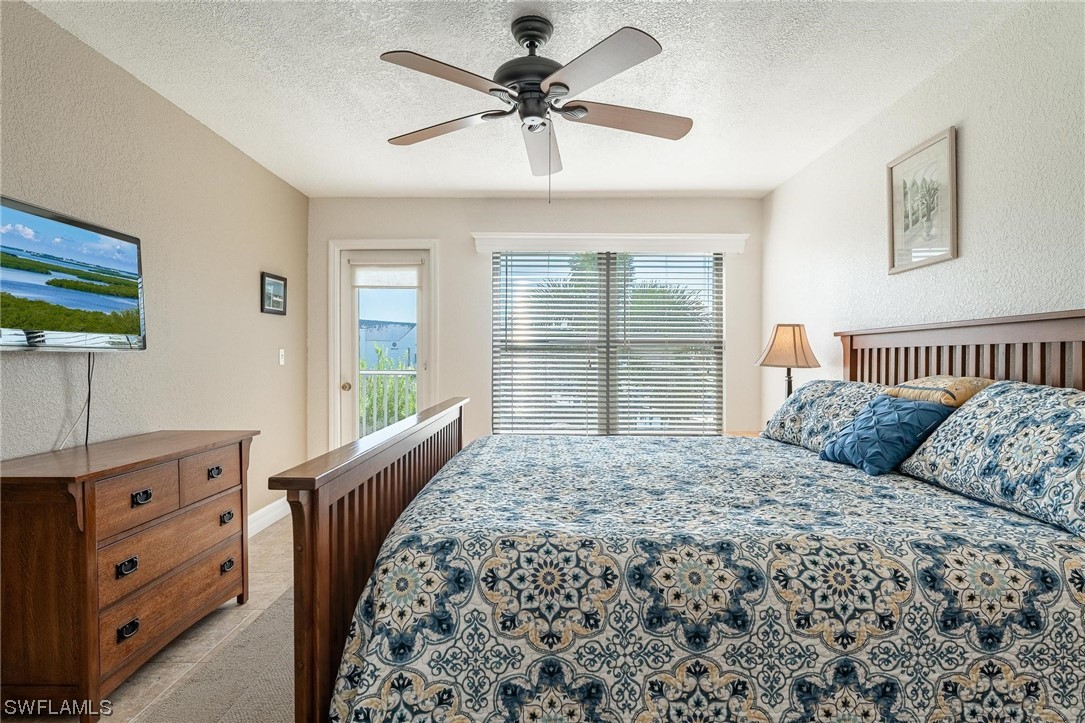 16641 Stringfellow Road, Unit 502 Bokeelia, FL 33922 - Photo 15 of 40 a bedroom with a bed and a chandelier
