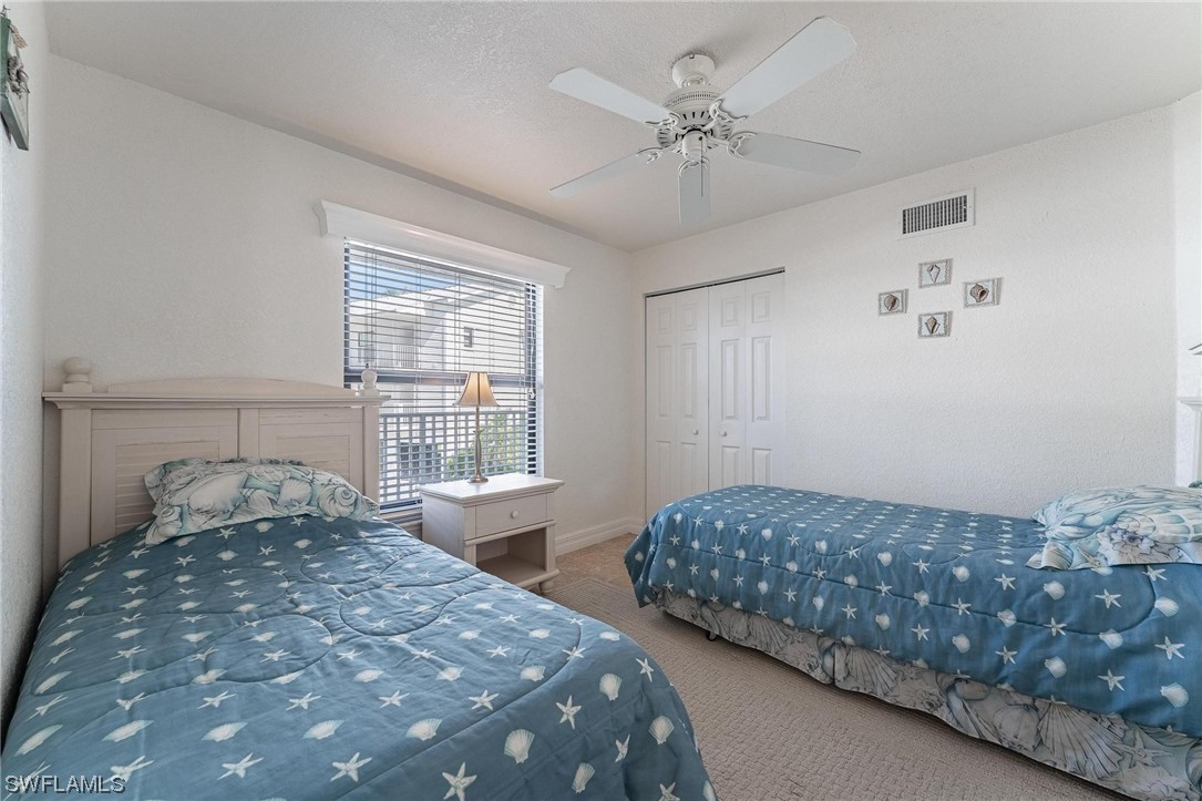 16641 Stringfellow Road, Unit 502 Bokeelia, FL 33922 - Photo 19 of 40 a bedroom with a large bed and a chandelier fan