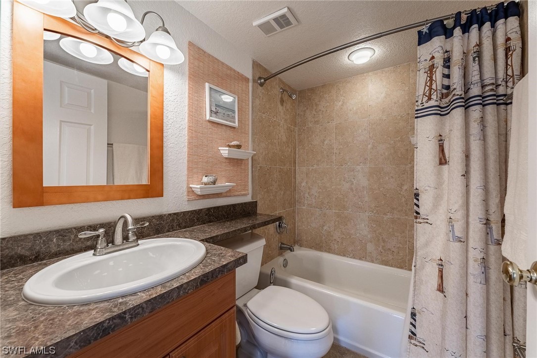 16641 Stringfellow Road, Unit 502 Bokeelia, FL 33922 - Photo 20 of 40 a bathroom with a granite countertop sink toilet and shower