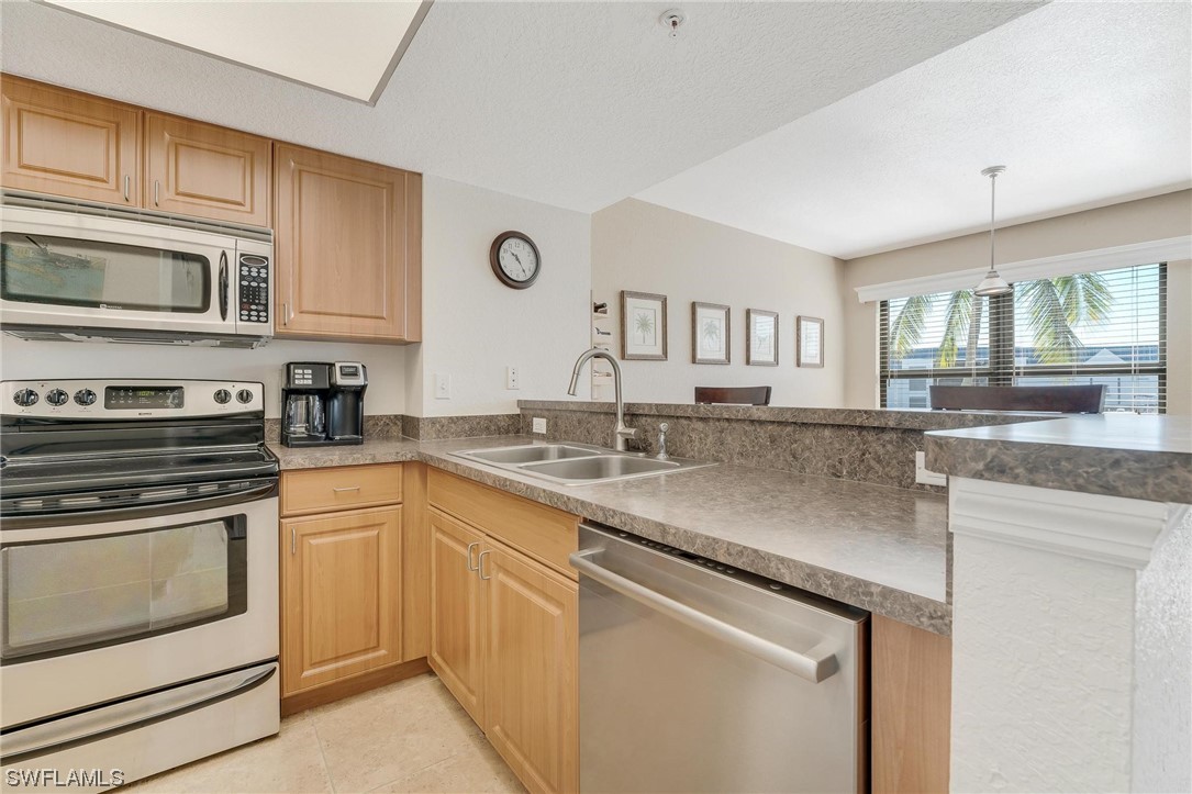 16641 Stringfellow Road, Unit 502 Bokeelia, FL 33922 - Photo 5 of 40 a kitchen with stainless steel appliances granite countertop a sink and stove top oven